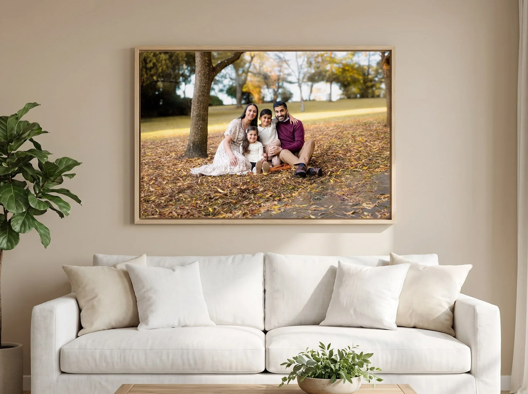 A large Faithful Photography canvas in a raw oak floating frame, hung above a white sofa